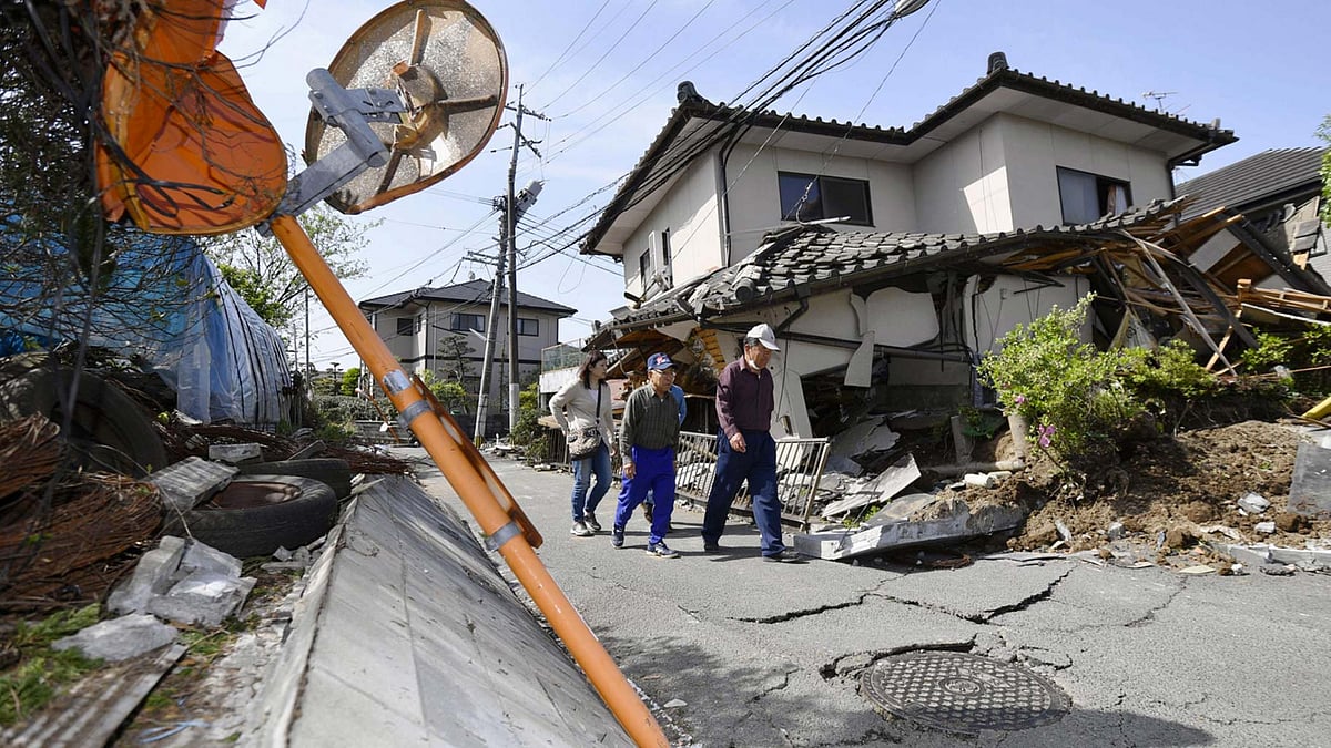 Residents walk past a house damaged by a magnitude-6.5 earthquake in Mashiki, Kumamoto prefecture, southern Japan, on Friday, 15 April 2016. (Photo: AP)