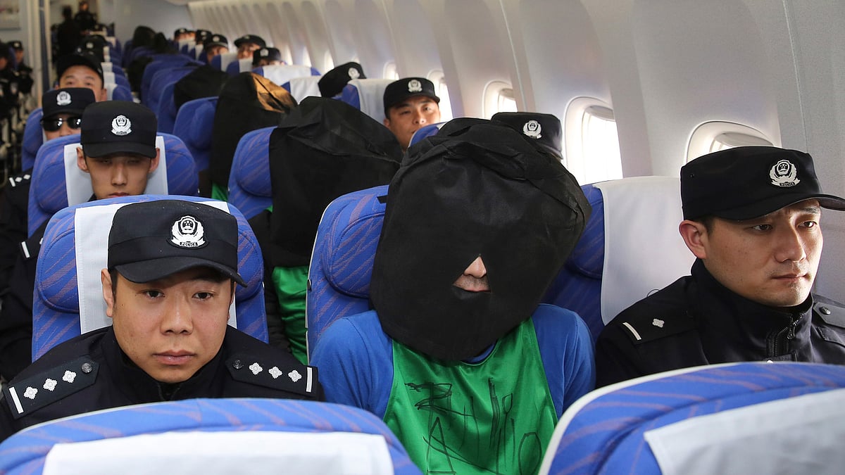 Chinese suspects involved in a wire fraud sit in a plane as they arrive at the Beijing Capital International Airport on Wednesday, 13 April 2016. (Photo: AP)
