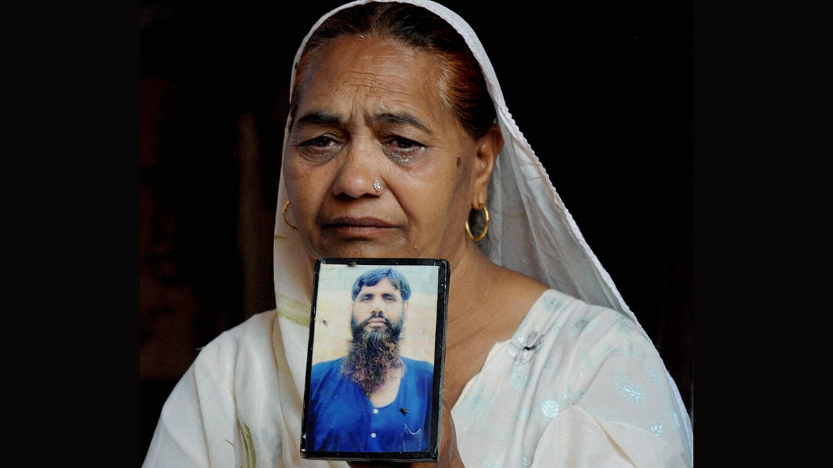 Jagir Kaur, Kirpal Singh’s sister, cries as she shows his photograph while mourning the news of his death in Amritsar on Tuesday. (Photo: PTI)