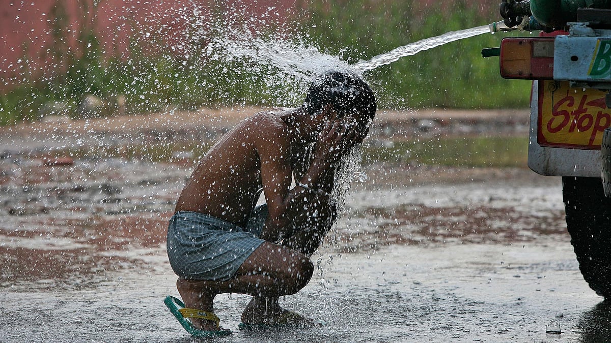 A child cools off in the sweltering heat. (Photo: Reuters)