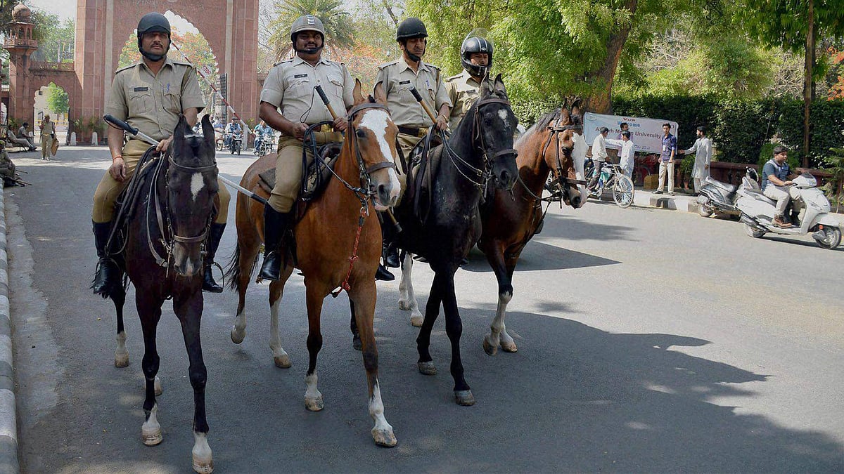 Police force deployed infront of Aligarh Muslim University gate after the clashes between two groups at University campus, in Aligarh on Sunday. (Photo: PTI)
