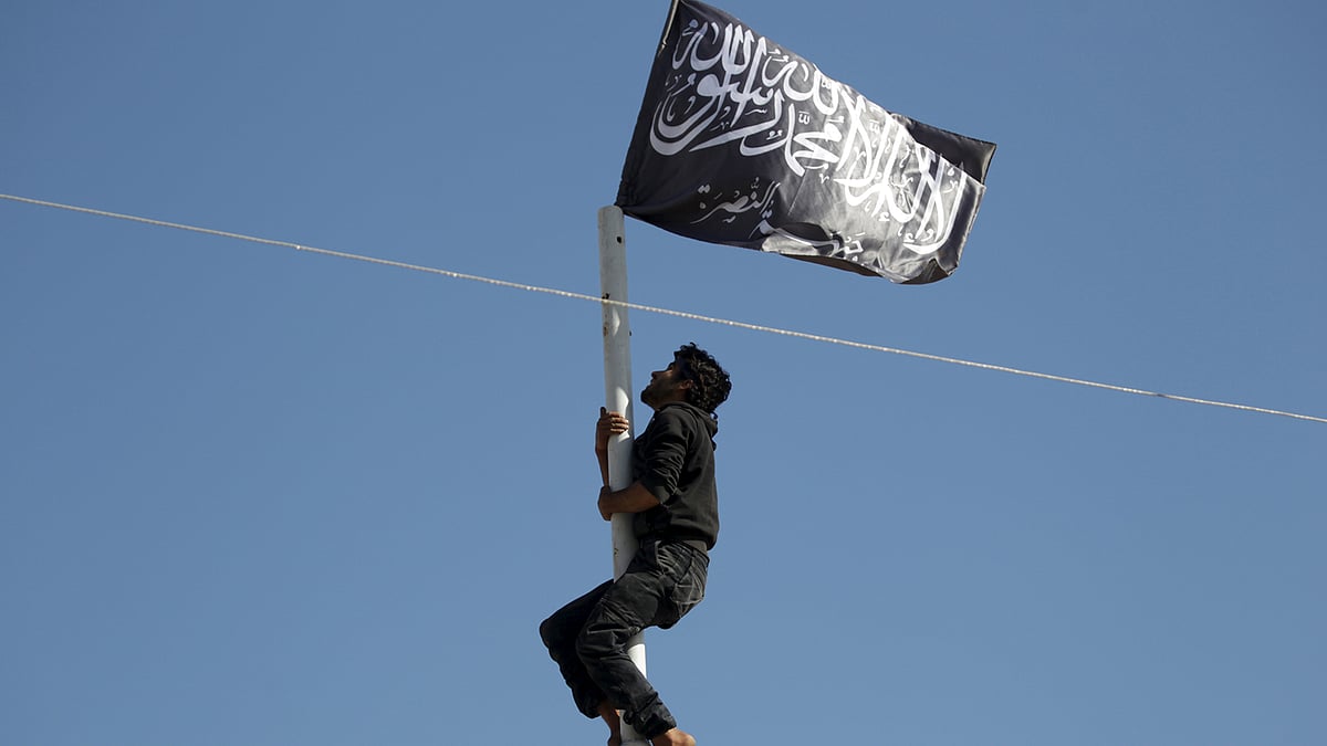 A member of Nusra Front adjusts a Nusra flag at a central square in the northwestern city of Ariha. (Photo: Reuters)
