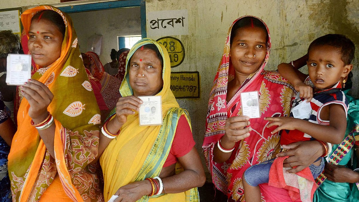 Women show their voter cards before casting votes at a polling booth during the state assembly elections in Kharagpur. (Photo: PTI)