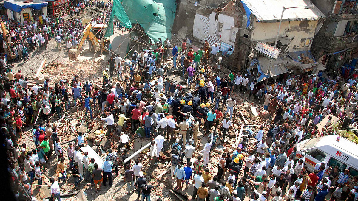 A crowd gathers near a building that collapsed at Kamathipura in Mumbai on Saturday. (Photo: PTI)