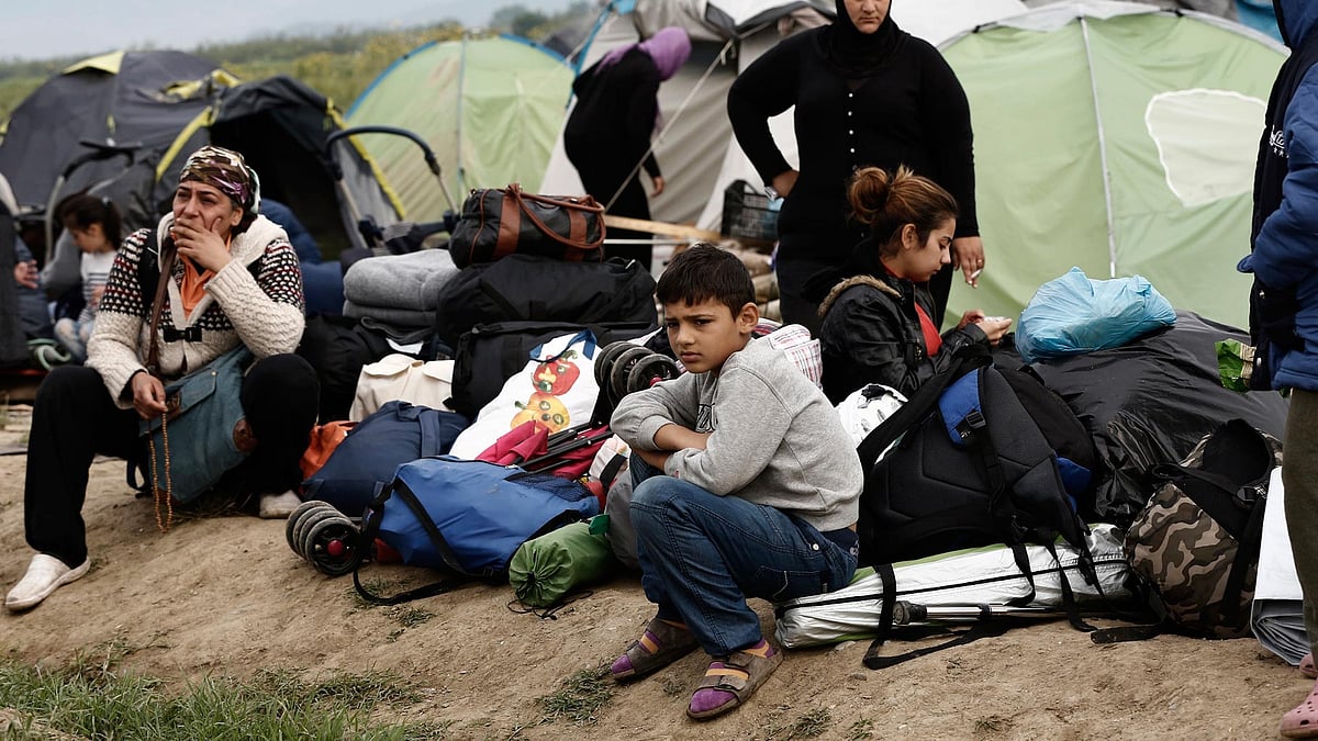 Refugees and migrants wait to embark into the buses during a police operation at a makeshift refugee camp at the Greek-Macedonian border. (Photo: AP)