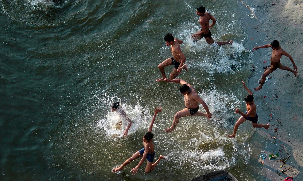 Boys  jump into a nearby lake to cool themselves down in this heat. (Photo: Reuters)
