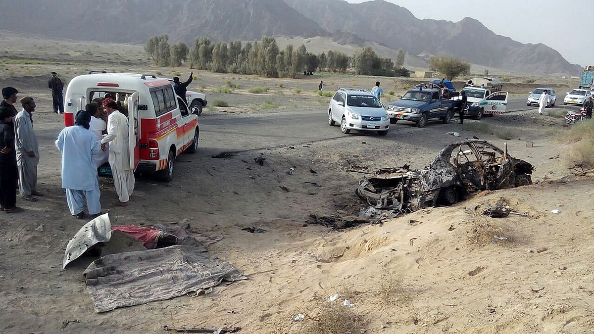 Volunteers stand near the wreckage of the destroyed vehicle, in which Mullah Mohammad Akhtar Mansoor was allegedly traveling in the Ahmed Wal area in Baluchistan province of Pakistan, near Afghanistan border. (Photo: AP)