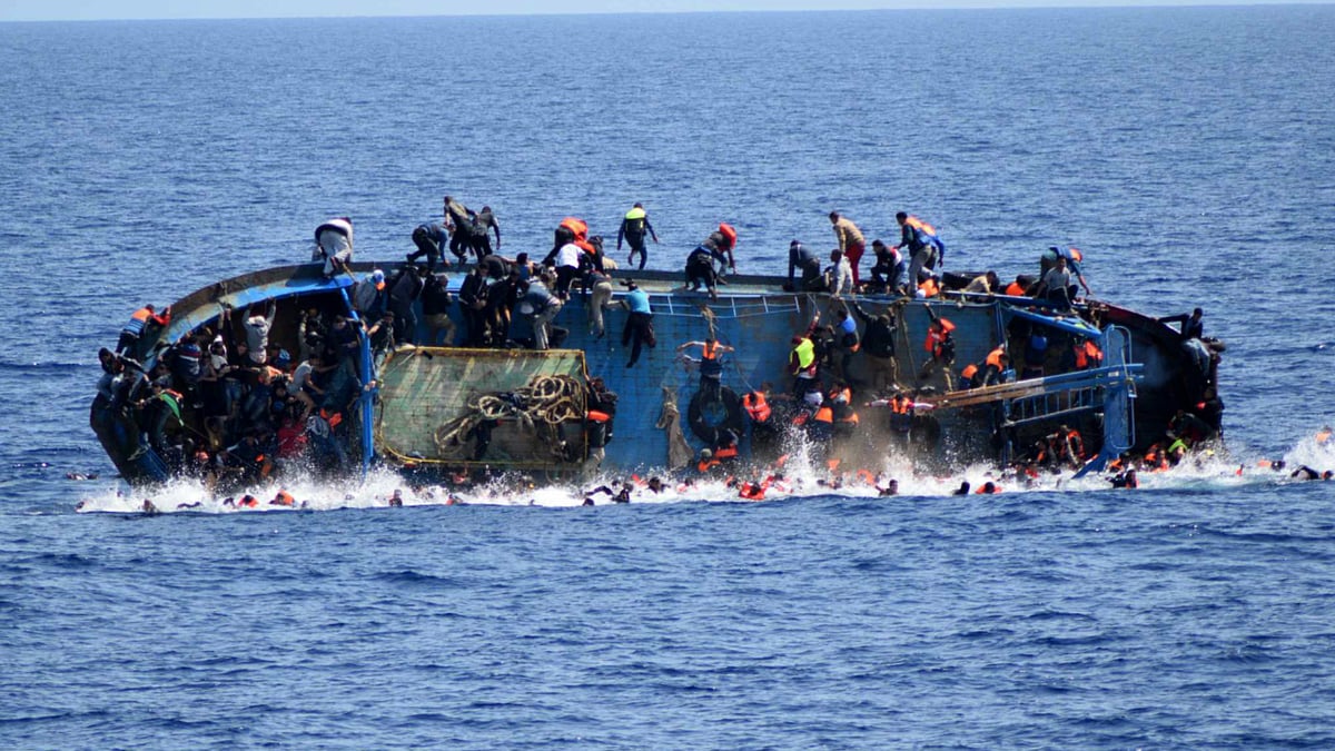 A photo of the capsized boat taken by the navy showed migrants scrambling up the side of the overturned ship. (ANI screengrab)