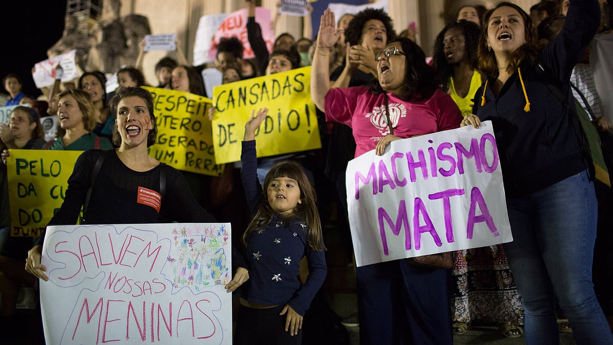 Demonstrators protest the gangrape of a 16-year-old girl in Rio de Janeiro, Brazil, Friday, 27 May 2016. Their signs read in Portuguese: “Save our girls,” left, and “Machismo kills.” (Photo: AP)