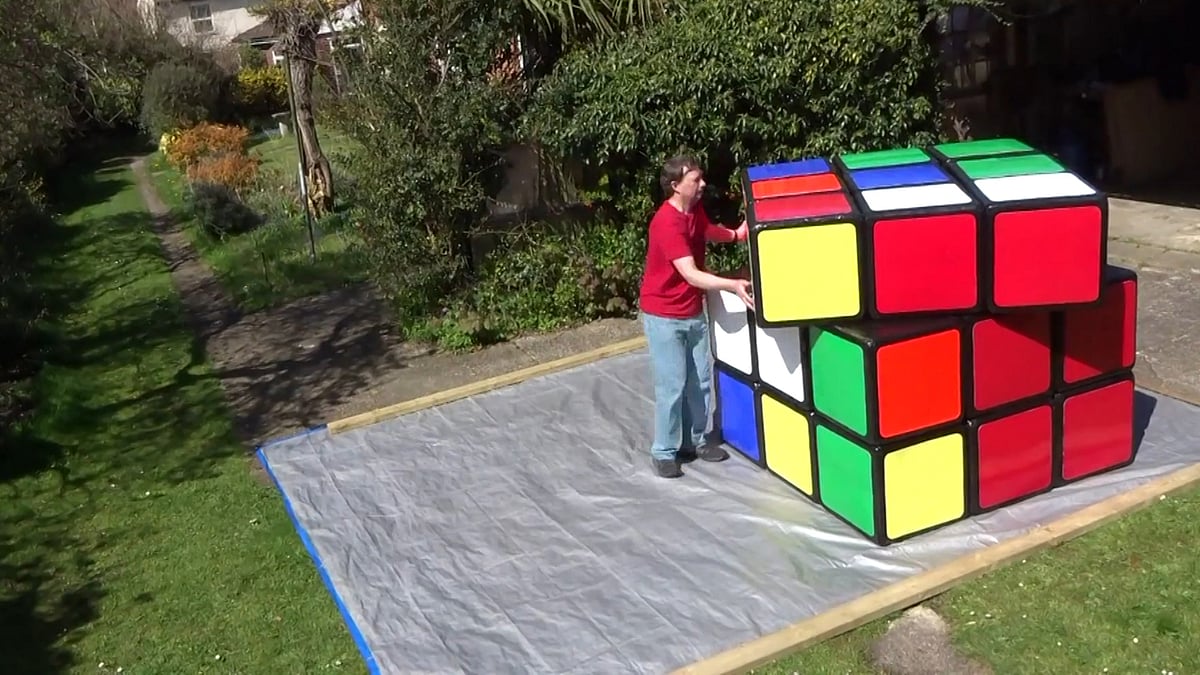 

Tony Fisher running around his massive cube to solve it in his lawns in Ipswich, UK. (Photo: AP/Newsflare screengrab)