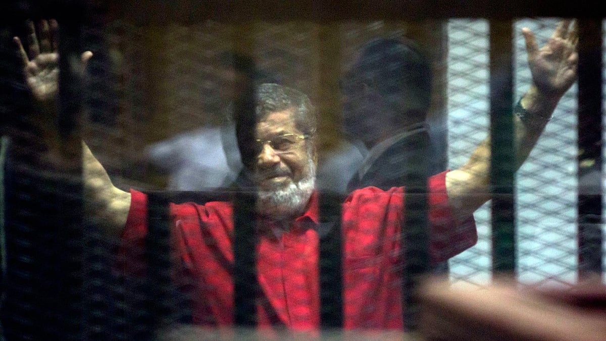 Former Egyptian President Mohammed Morsi raises his hands in a makeshift courtroom at the national police academy, in an eastern suburb of Cairo, Egypt, Saturday, 18 June 2016. (Photo: AP)