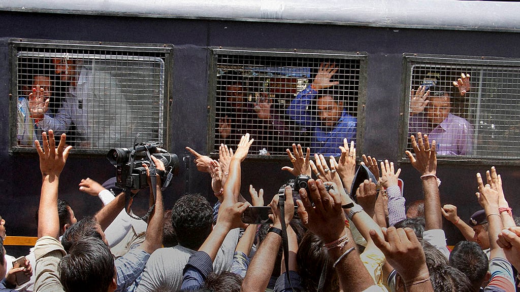 Family members wave to the Gulbarg Society massacre case convicts as they are taken away in van, after the verdict on the case by a special SIT court in Ahmedabad. (Photo: PTI)