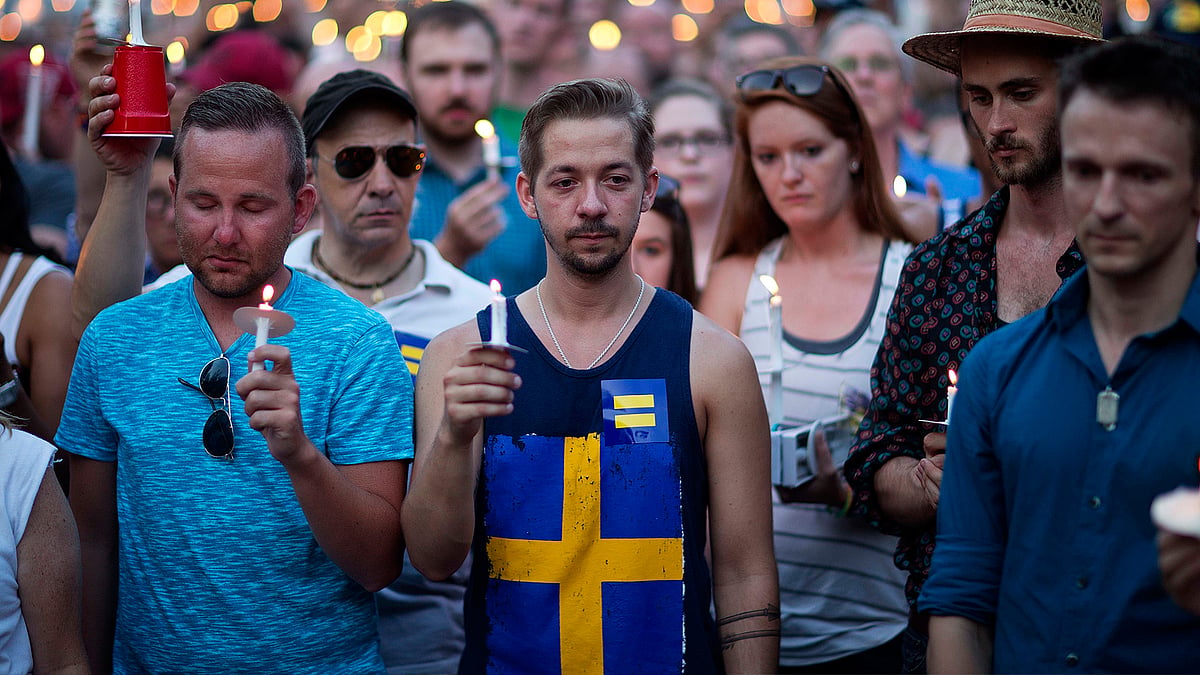 Mourners observe a moment of silence during a vigil for victims of a fatal shooting at an Orlando nightclub on Sunday. (Photo: AP)