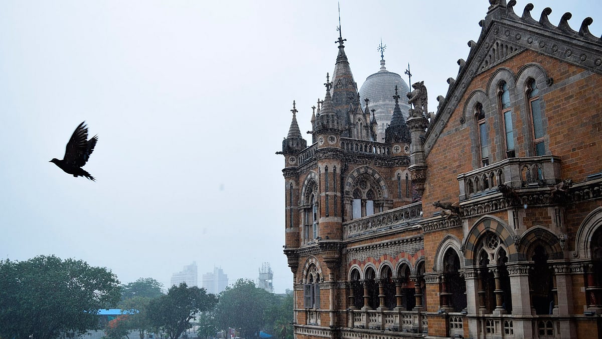 A crow flies past the iconic Victoria Terminus in Mumbai, after a burst of monsoon rain. In the background lie the modern, sleek residential buildings of South Mumbai. (Photo: <b>The Quint</b>/Pallavi Prasad)&nbsp;