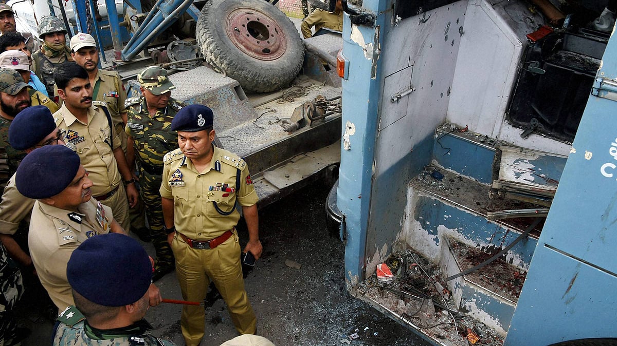 Security forces inspecting the CRPF bus attacked by militants on the Srinagar-Jammu National Highway at Pampore in Srinagar, 25 June 2016. (Photo: PTI)
