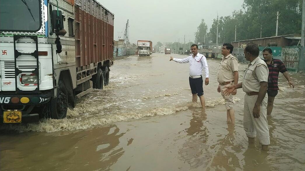 A traffic policeman directs traffic in waterlogged Gurgaon on Friday morning. (Photo Courtesy: Twitter/<a href="https://twitter.com/gurgaonpolice/media">GurgaonPolice</a>)