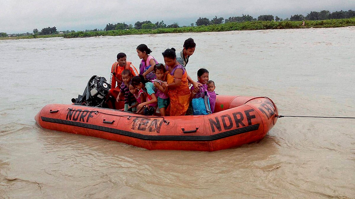 Disaster Response Force (NDRF) jawans rescue flood affected villagers , at Chirang district in Assam. (Photo: PTI)