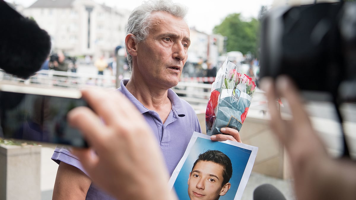 

A heart-wrenching image of a grieving father, Niam Zabergja, holding a photograph of his deceased son Dijamant Zabergja. (Photo: AP)