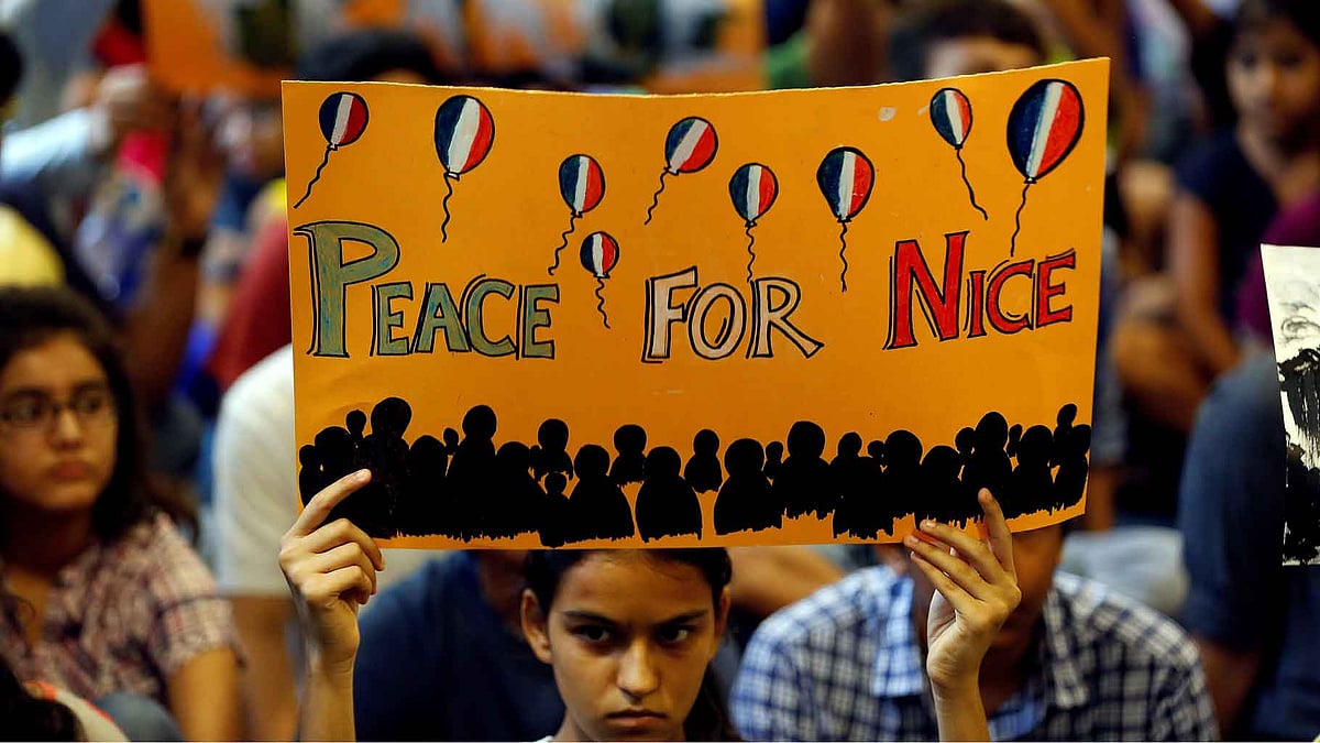 A girl holds up a placard during a prayer meet to show solidarity with the victims of the Bastille Day truck attack in Nice, at a school in Ahmedabad. (Photo Courtesy: Reuters)