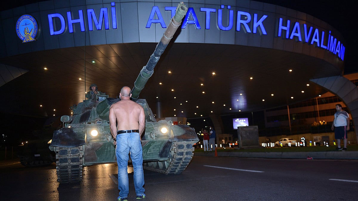A man stands in front of a tank in the entrance to Istanbul’s Ataturk airport, early Saturday, July 16, 2016. (Photo: AP)