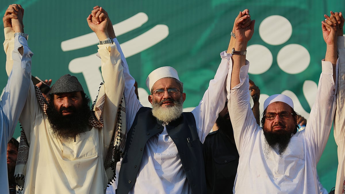 Hafiz Saeed, chief of Jamaat-ud-Dawa joins hands with Sirajul Haq, center, and the leader of Hizbul Mujahideen Syed Salahuddin, left, during the anti-Indian rally in Islamabad. (Photo: AP)