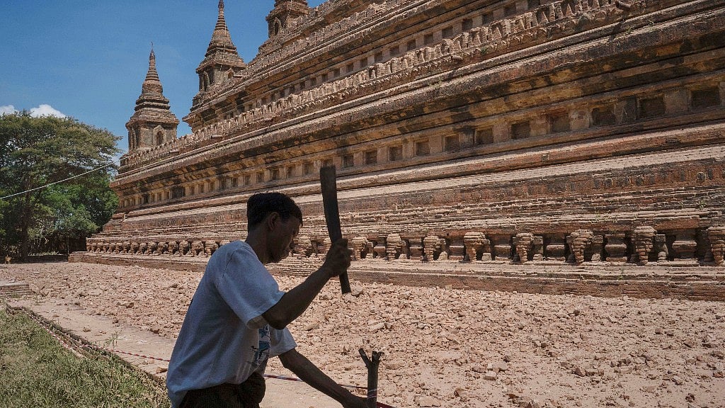A man nails a stake to set up a security perimeter around earthquake effected Sitanagyi Pagoda in Bagan. (Photo: AP)
