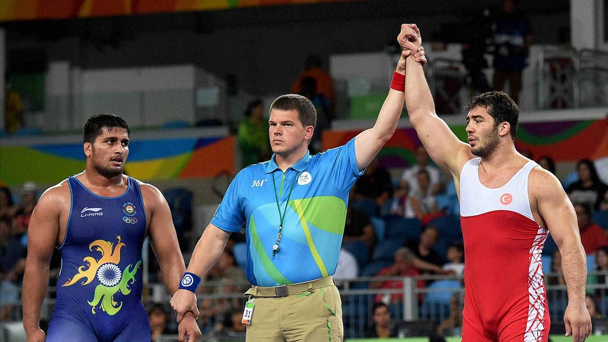 Rio de Janerio: Ildem Cenk of Turkey is declared the winner against India’s Hardeep Singh (Blue) in Men’s 98 Kg wrestling. (Photo; PTI)