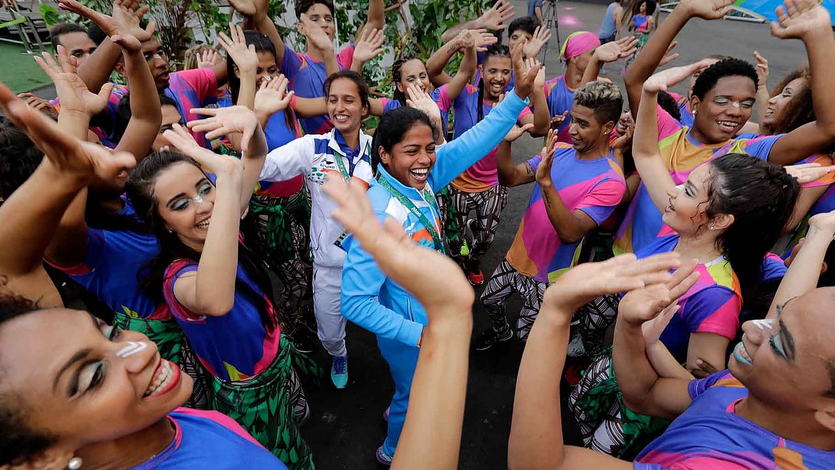 Indian field hockey players Deepika, center right, and Preety Dubey, center left, dance with performers after a welcome ceremony at the Olympic athletes village in Rio de Janeiro, Brazil. (Photo: AP)