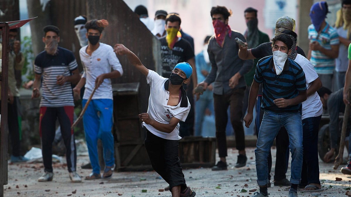 Masked Kashmiri protesters throw bricks at the paramilitary soldiers during a protest in Srinagar, 28 July, 2016. (Photo: AP)