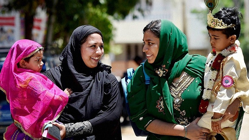 

Muslim women carry their children dressed as Radha and Krishna on Janmashtami.