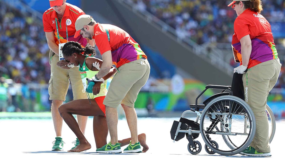 Etenesh Diro (ETH) of Ethiopia receives help after she competed most of the race without one shoe. (Photo: Reuters)