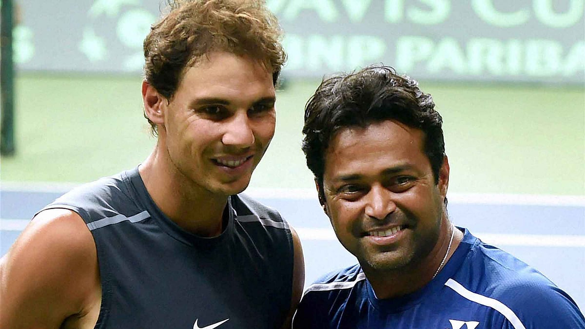  Spain’s Rafael Nadal with India’s Leander Paes poses for photographs during a practice session in New Delhi. (Photo: PTI)