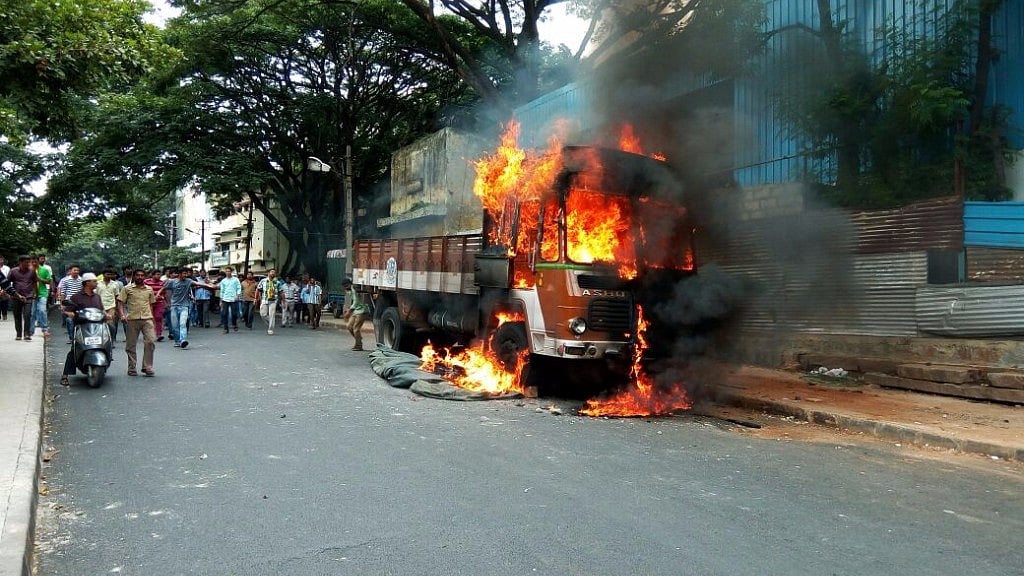 Vehicles with Tamil Nadu numbers were torched and burned by protesters in Bengaluru. (Photo: IANS)
