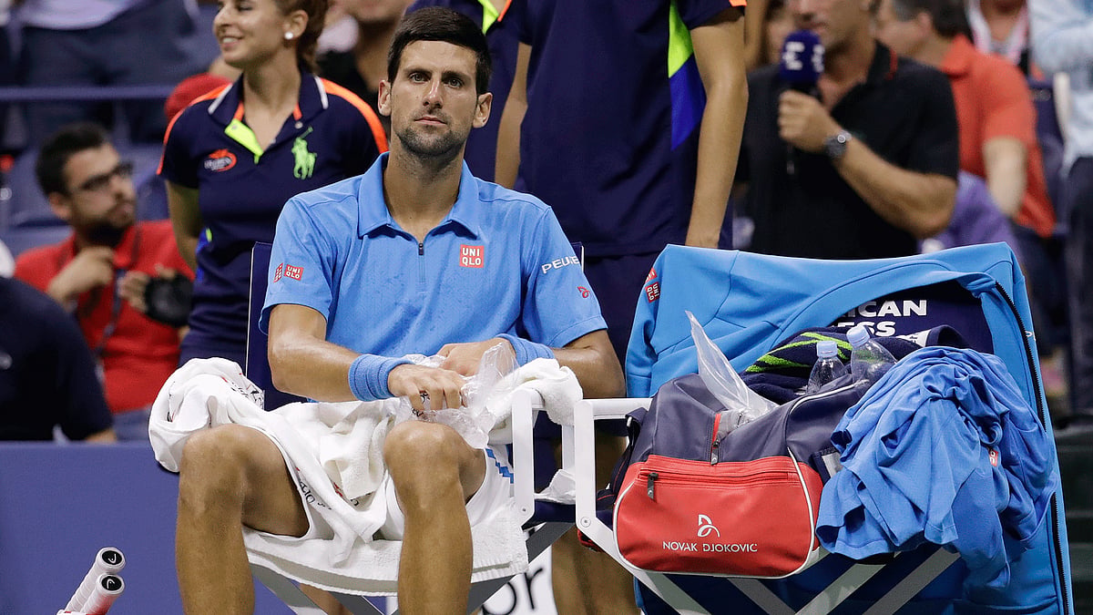 Novak Djokovic, of Serbia, applies ice to his leg between games against Stan Wawrinka, of Switzerland. (Photo: AP)