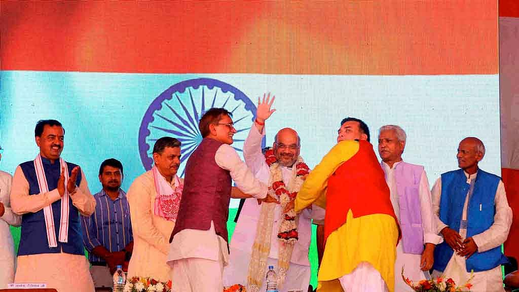 BJP National President Amit Shah is garlanded at a public meeting at Pt. Deen Dayal Dham in Farah, Mathura on Wednesday. (Photo Courtesy: PTI) 