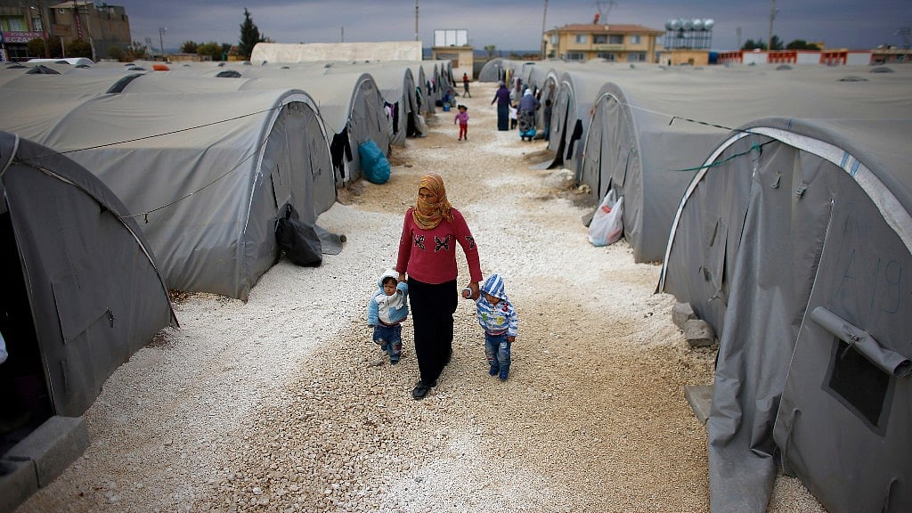  A woman walks with two children in a refugee camp. Image used only for representational purposes. (Photo: Reuters)