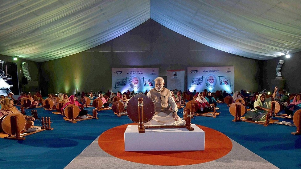 Modi also went around an exhibition and tried his hand at a Charkha. (Photo: PTI)