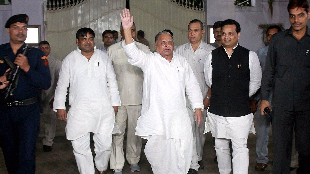 Samajwadi Party chief Mulayam Singh Yadav waves to his party workers as he come out after meeting at his residence in Lucknow. (Photo: PTI)