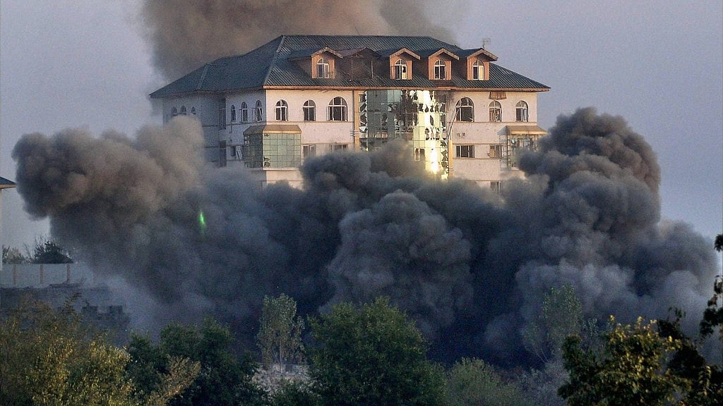 Smoke billowing out of the multi-storied government building where some militants were holed up during a gunbattle with the army at Pampore, 16 km from Srinagar, on Monday. (Photo: PTI)
