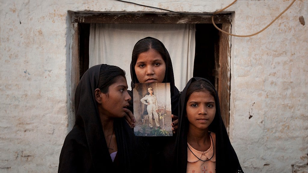 Aasia Bibi’s daughters hold an image of their mother outside their residence in Sheikhupura, located in Pakistan’s Punjab province, on 13 November 2010. 