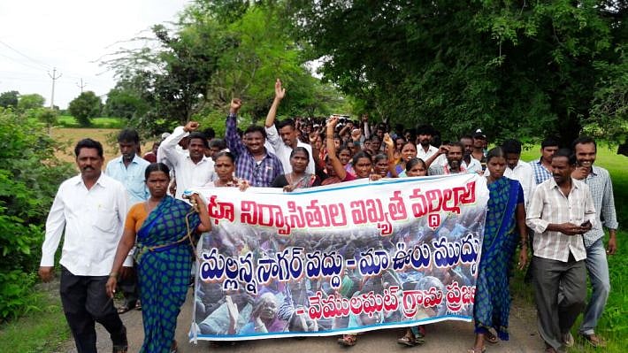 Villagers hold a poster that says “We don’t want Mallannasagar, we want our village.” (Photo: The News Minute) 