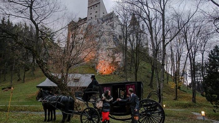 Tami Varma is helped out of a horse-drawn carriage by guide near the northern facade of the Bran Castle, in Brasov county, Romania, 31 October, 2016. (Photo Courtesy: Reuters)