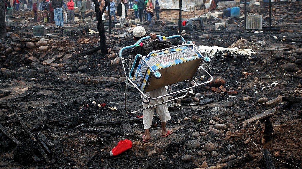 Myanmar refugees look for  belongings after a fire at a slum area in the outskirts of Jammu. (Photo: Reuters)