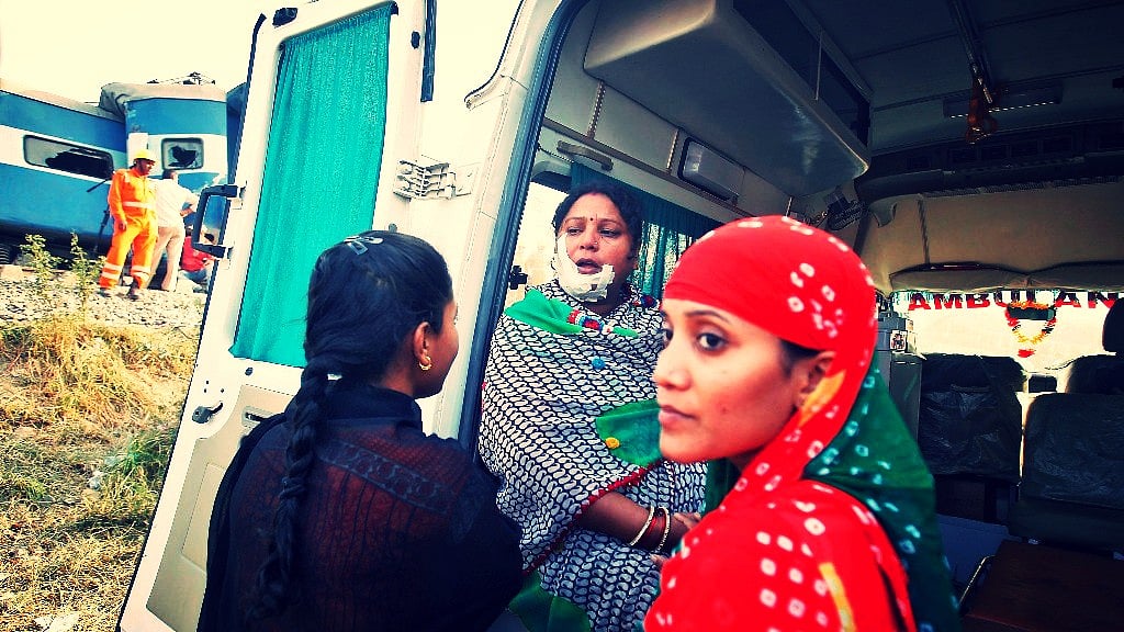 An injured woman sits at the back of an ambulance at the site of a train derailment in Pukhrayan, Kanpur. (Photo: Reuters)