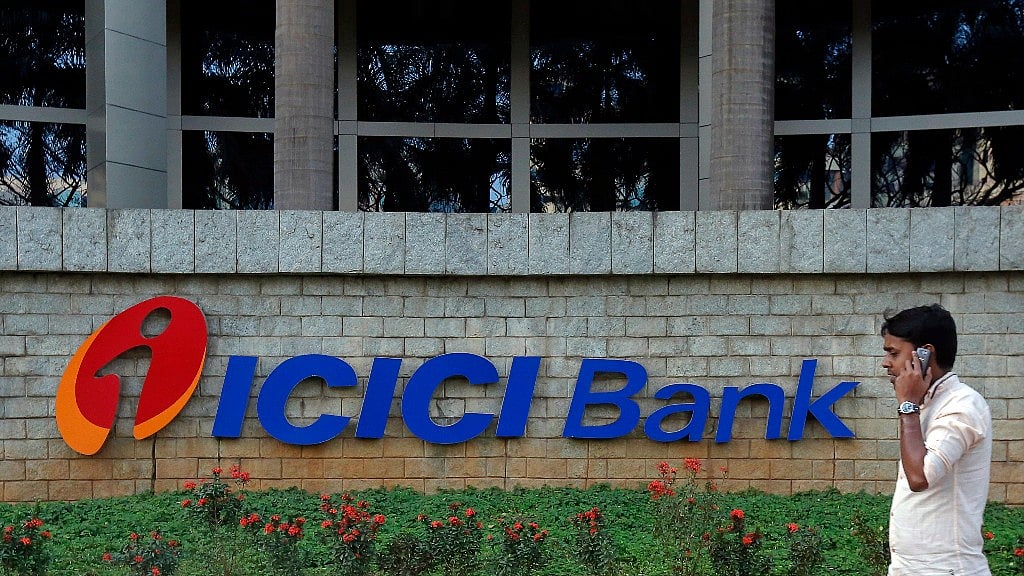 A pedestrian walks past a logo of ICICI Bank at its headquarters in Mumbai.