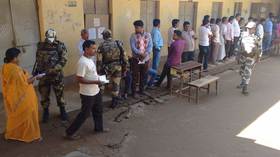 Voters stand in a queue in a polling centre as central paramilitary forces keep vigil during by-election in Barjala constituency, West Tripura district on 19 November 2016. (Photo: IANS)