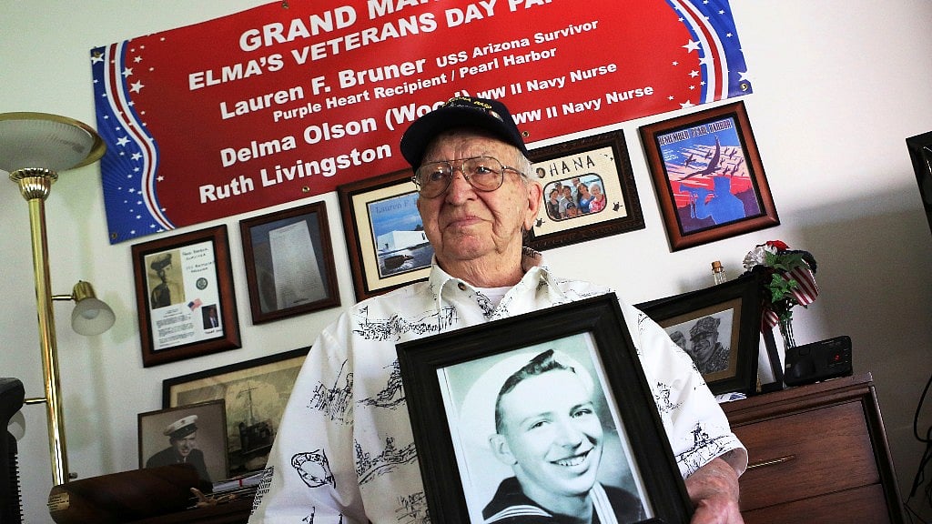Lauren Bruner, one of five remaining survivors of the USS Arizona, which was attacked on 7 December 1941, holds a photo of himself from 1940. (Image: AP)