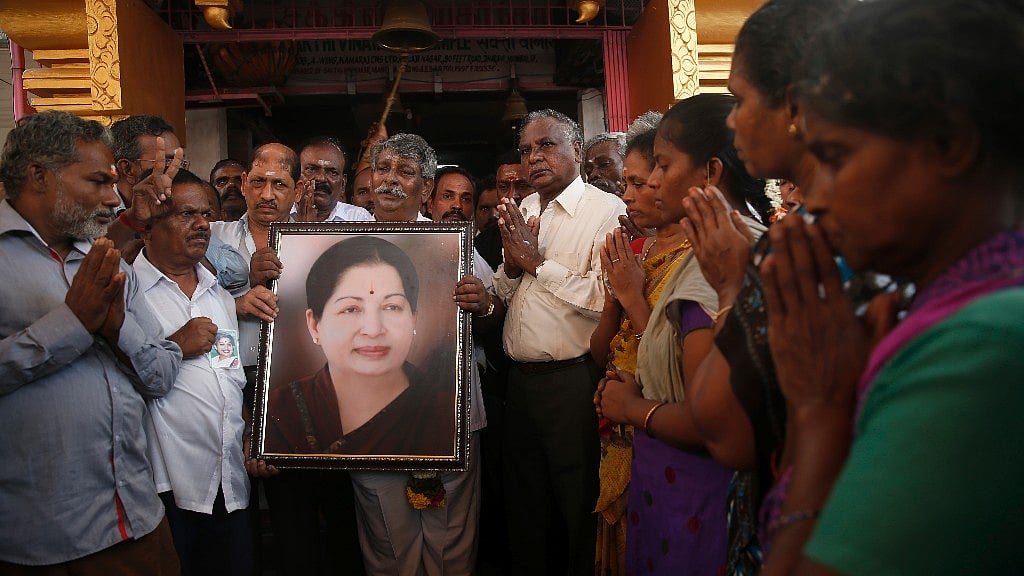 Mourners hold a photo of late Tamil Nadu Chief Minister Jayalalithaa. (Photo: AP)