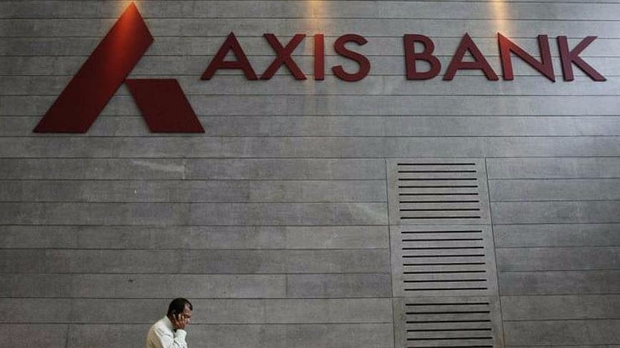 An employee walks in front of an Axis Bank sign.&nbsp;