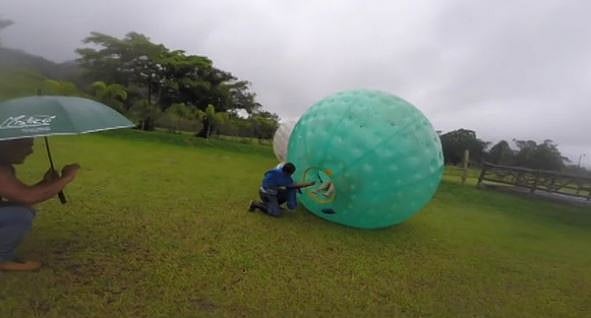 The orb which is filled with water, slides down a slope while the couple is ‘locked’ inside. (Image: AP Screengrab)